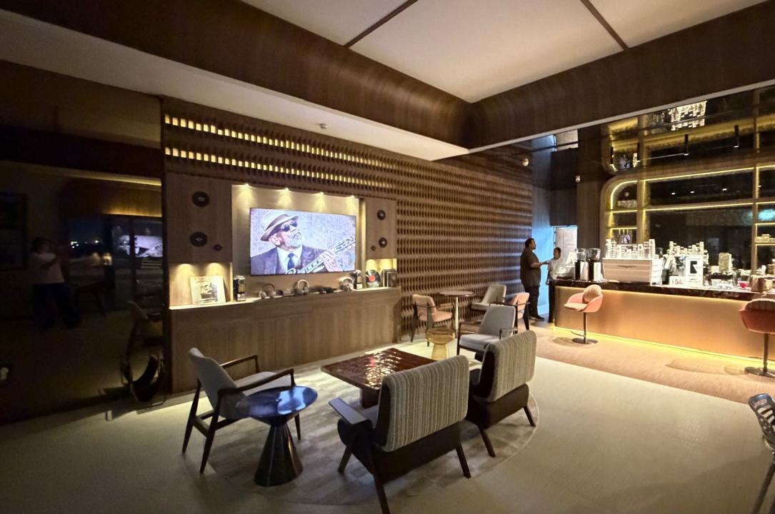 Lounge seating between the media wall and the underlit bar counter