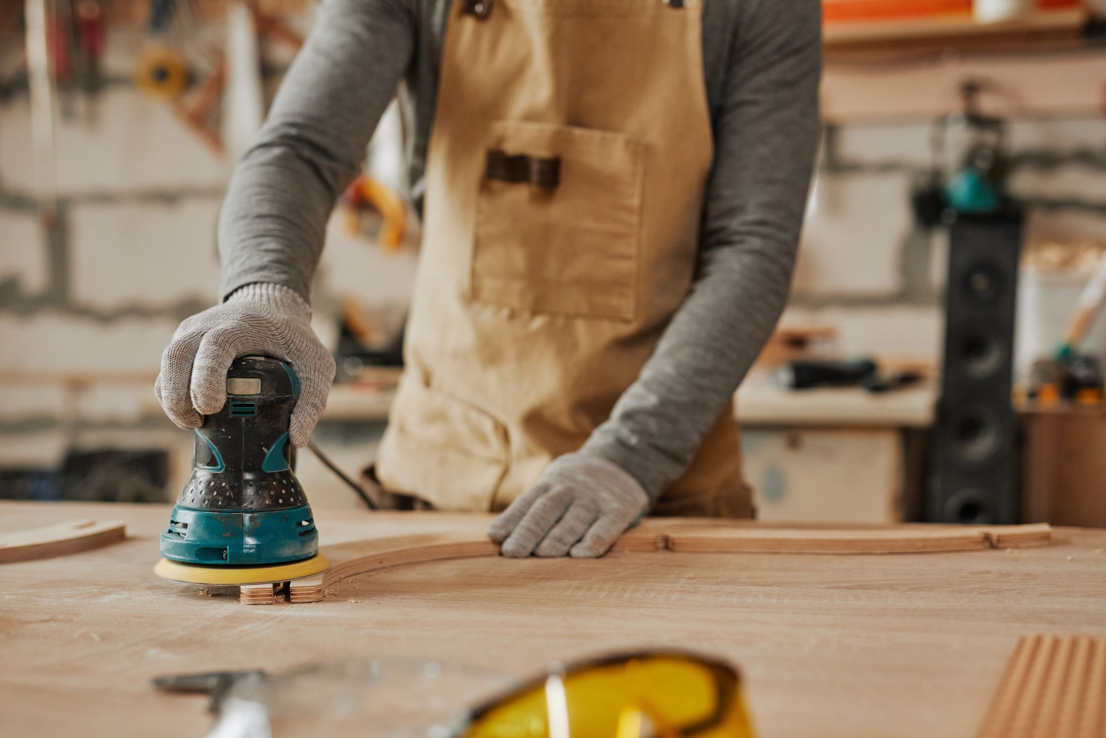 Craftsman sanding a timber panel in the workshop